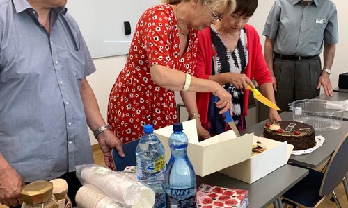Zdjęcie przedstawia pracownik&oacute;w SJO krojących tort